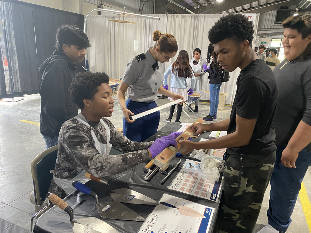 CTE student explains concepts with level in hand to another student during the Robeson County Career Center Showcase Event